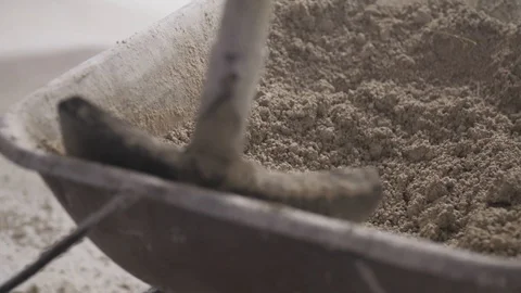 Taking sand from a wheelbarrow Stockbeeldmateriaal 91547721