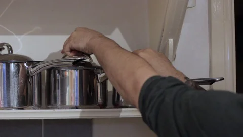 Taking a saucepan off a shelf for use Stock Footage 94641440