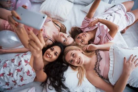 Taking selfie with friends while lying on the bed at bachelorette party Stock-Fotos
