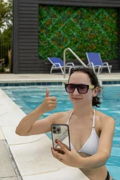 Taking a selfie by the pool while working remotely during a sunny day Фото