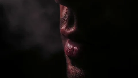 Taking several hits of a marijuana joint. Low key shot. Stock Footage 82877202
