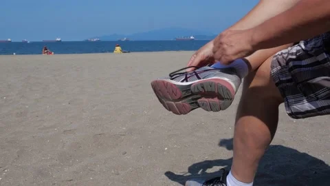 Taking shoes off at the beach. Close up. 库存影片 158287927
