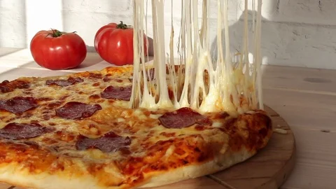 Taking slice of pizza with super stretching cheese Stock Footage 72458840