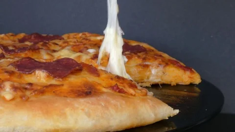 Taking slice of pizza with super stretchy cheese Stock-Footage 72458567