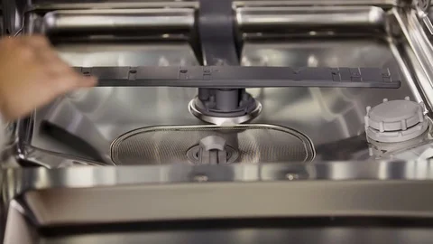Taking a small item out of the dishawasher and adjusting it back inside Stock Footage 69940290