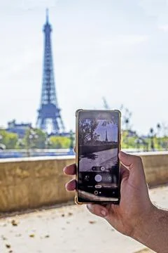 Taking a smartphone photo of the Eiffel Tower in the distance on a hot day .. 写真素材
