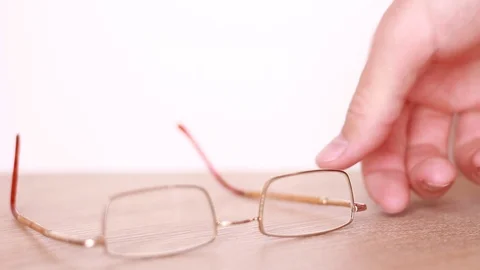Taking spectacles from the table Vídeo Stock 88764003