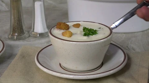 Taking a spoonful of clam chowder Stock Footage 94318546