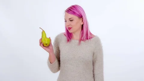 Taking off a stem and then biting into a delicious pear Stock Footage 83724557
