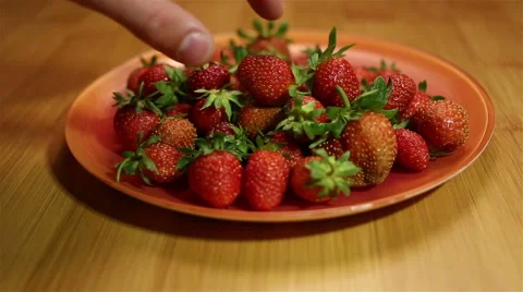 Taking a strawberry from plate Video stock 64972558