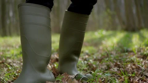 Taking a stroll in the great outdoors while wearing vibrant green rubber boots Stock Footage 306013261