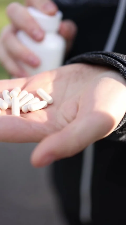 Taking supplements while running Video stock 333100608