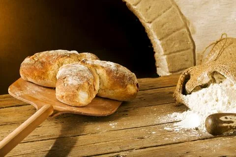 Taking swiss bread from the oven Stock Photos
