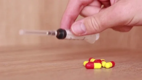 Taking syringe and pills from the table Vídeos de archivo 82196431