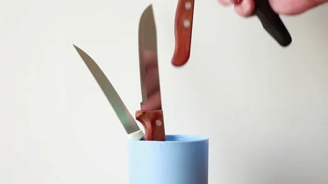 Taking table knifes from plastic can Stock Footage