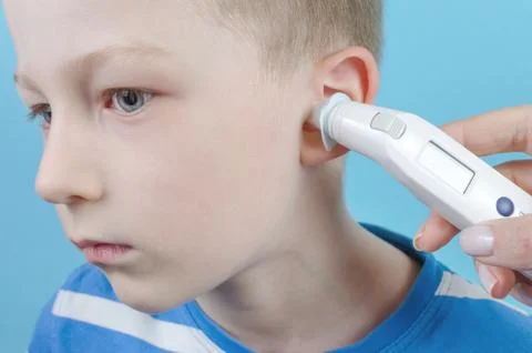 Taking temperature with ear thermometer by child Stock Photos