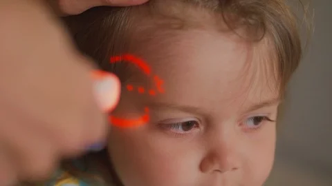 Taking temperature of sick child by infrared thermometer Stock Footage 119531340