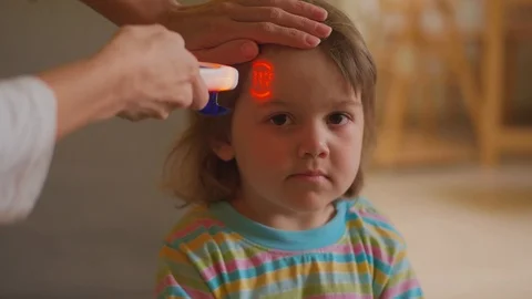 Taking temperature of sick child by non-contact thermometer Stock Footage 119528306