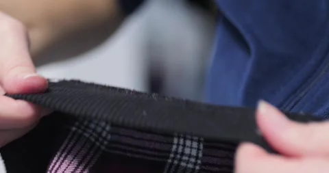 Taking thread out of pant seams 4K close-up video Stock Footage 301861745