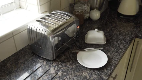 Taking Toasted white crusty bread out of toaster and spreading butter Stock Footage 111712740