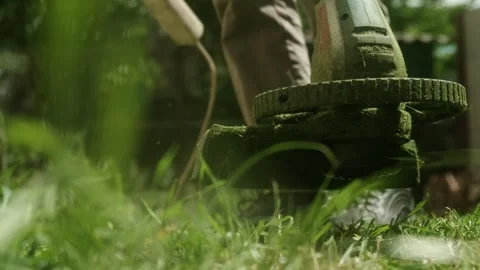 Taking trimmer to finish garden work on a sunny day. Realistic lawn trimming Stock Footage 310667752