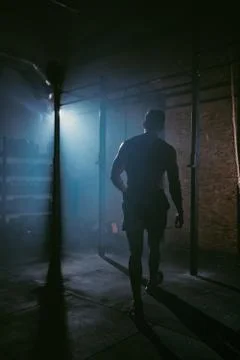 Taking video from the back of athletic guy in a dark crossfit class wanting to Stock Photos