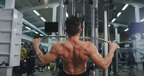 Taking video from the back bodybuilding man exercises at gym class concentrated Stock Footage 116035921