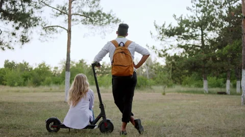 Taking video from the back of a couple after the work they came to the park and Stock Footage 146980835
