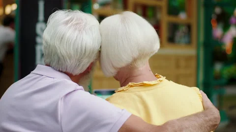Taking video from the back of a romantic old couple hugging each other at the Stock Footage 164745335