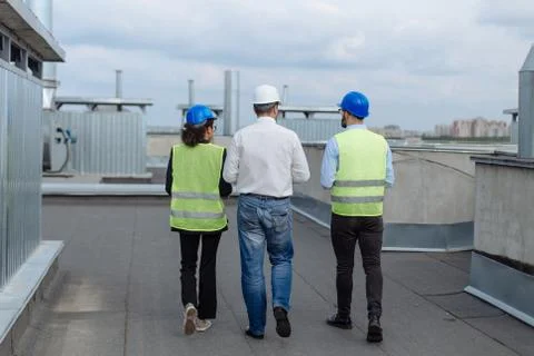 Taking video from the back rooftop of construction site one architect and two Foto stock