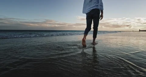 Taking video of a guy walking through the seaside he enjoying the time alone Stock Footage 141034035