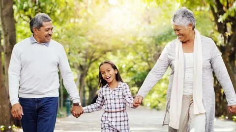 Taking a walk with our bundle of joy. an adorable little girl holding hands with Stock Photos