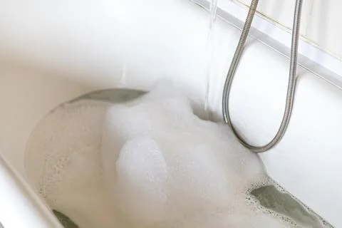 Taking water with foam into the bath, spa, relaxation Stock Photos