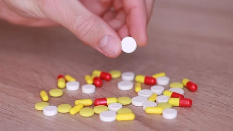 Taking white pill from pile 動画素材 93861360