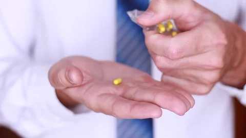 Taking yellow pill from pack Stock Footage 90442728