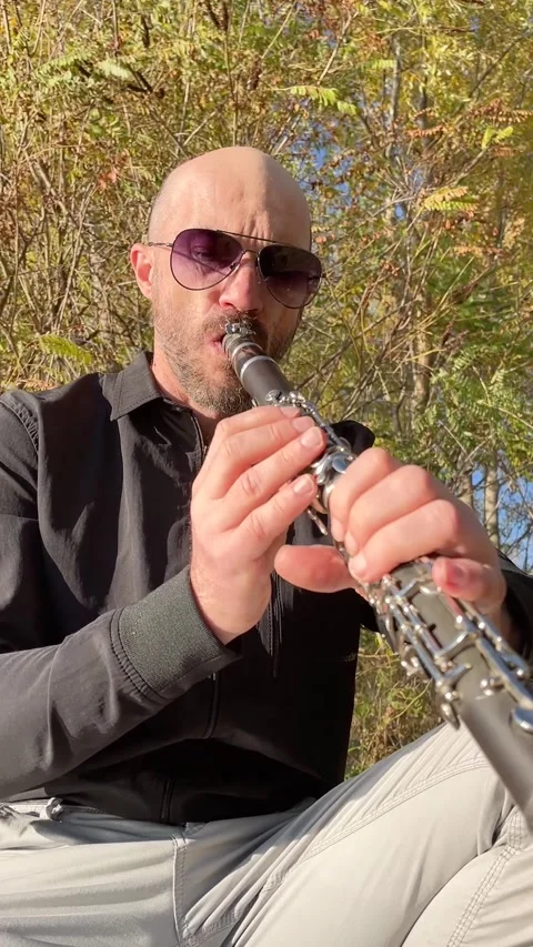 Talented Bald Man in Sunglasses Playing Clarinet Wind Instrument Outdoors Video stock 338441010