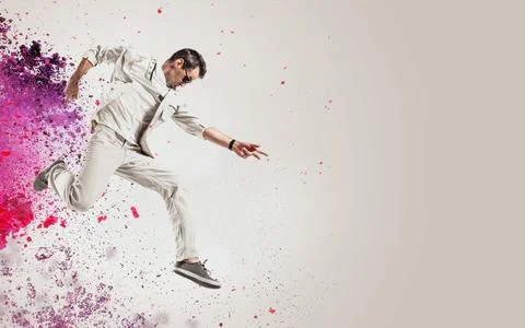 Talented dancer jumping out of paint splash Stock Photos