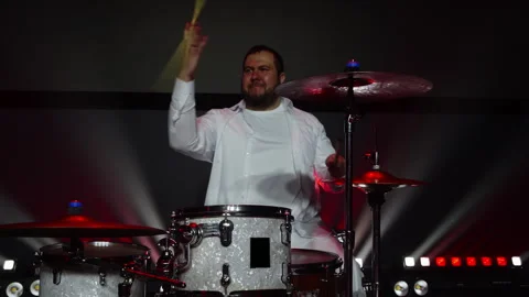 Talented drummer playing music on drumset on illuminated stage at event Stock Footage 295012196