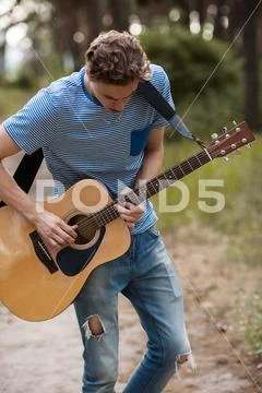 Talented guitarist playing forest hiking concept. Stock Photos
