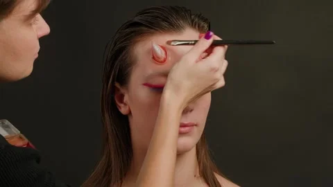 A talented Makeup Artist is skillfully applying cosmetics to enhance a models Stock Footage 295059525