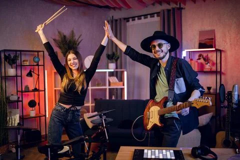Talented musicians holding hands up while standing at studio 스톡 사진