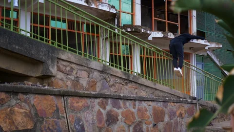 Talented parkour guy doing stunts and somersaults in the warehouse  Stock Footage 117606524