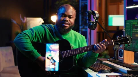 Talented performer teaching how to play acoustic guitar online for a tutorial Stock Footage 281454376