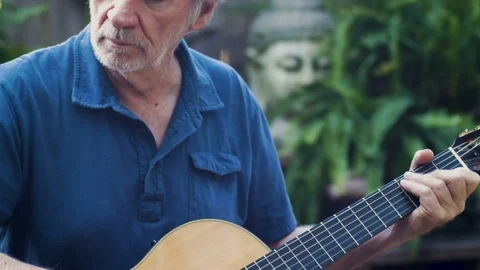 Talented senior man playing classical guitar and finger picking music Stock Footage 78615228