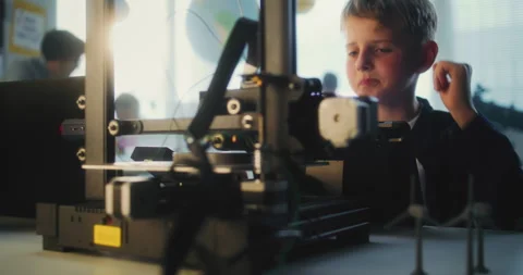 Talented Young Boy Sitting at Table, Writing Code for Automated 3D Printer on Stock Footage 311672768