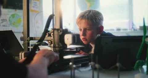 Talented Young Boy Sitting at Table, Studying Advanced Automated 3D Printer in Stock Footage 311673279