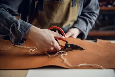 A talented young guy helps his father in the family business, cuts out blanks Stock Photos