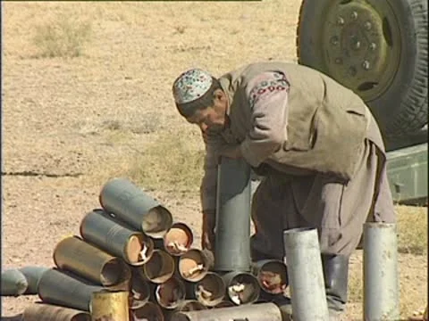 Taliban fighter preparing munitions and walking over to Howitzer. Stock Footage 10577700