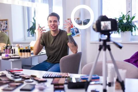 Talkative dark-haired man actively gesturing on camera Stock Photos
