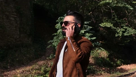 Talking cell phone, man talking on the phone in the forest, mobile Stock Footage 165848942